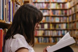 Person reading a book at the library